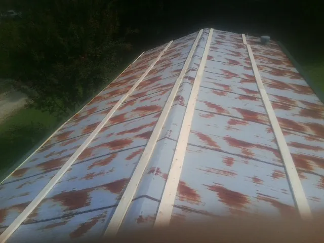 Rusted metal roof panels with new wood purlins before replacement — Storm Damage Roof Repair in Virgin by Roofing Brothers
