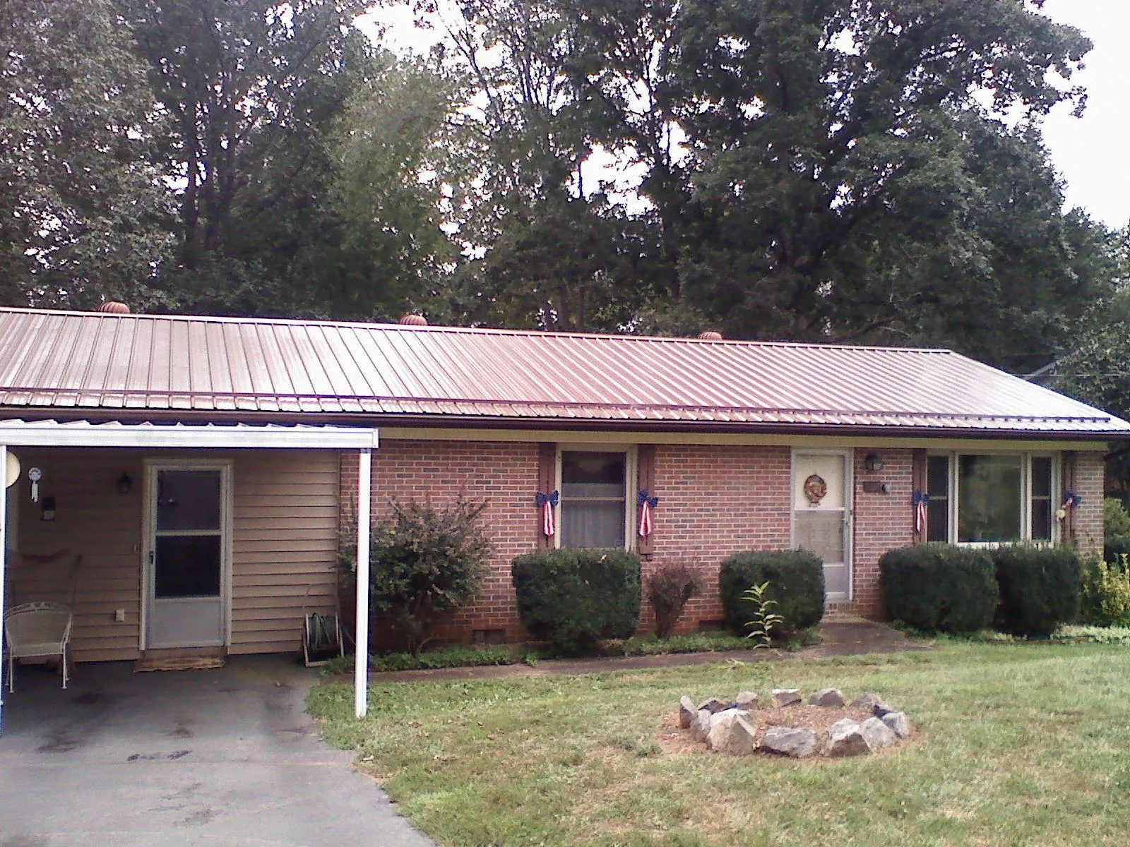 Bronze metal roof and carport on a brick ranch home — Roof Repair work by our crew in Virgin